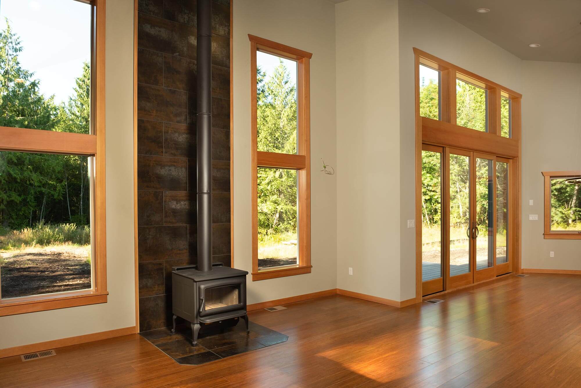 Living Room Wood Wrapped Vinyl Windows Slider Doors - Wood Burning Stove with Porcelain Tile Surround
